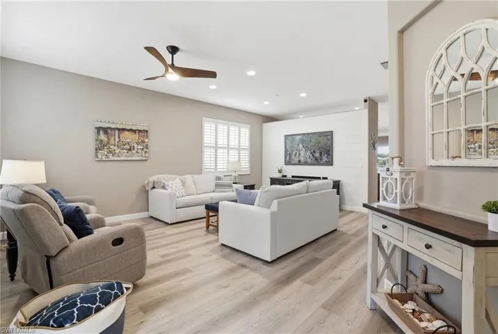 Living room featuring light wood-style flooring, a ceiling fan, and recessed lighting