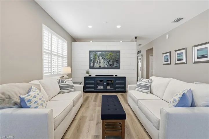 Living area featuring light wood finished floors and recessed lighting