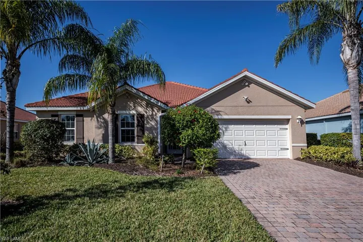 Ranch-style home featuring a garage and a front lawn