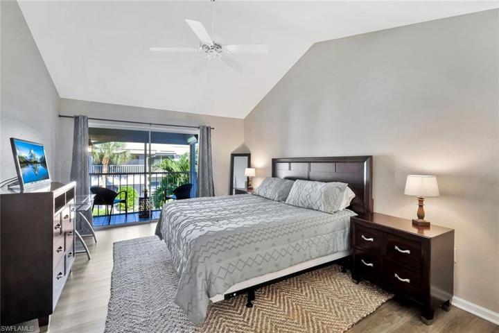 Spacious primary bedroom with a balcony overlooking the serene grounds of Sandpiper at Bonita Bay!