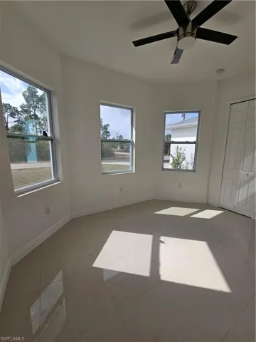 Unfurnished bedroom with multiple windows, a ceiling fan, and light tile patterned flooring
