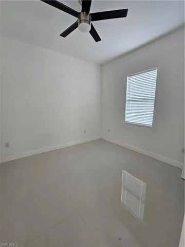 Spare room with baseboards and ceiling fan
