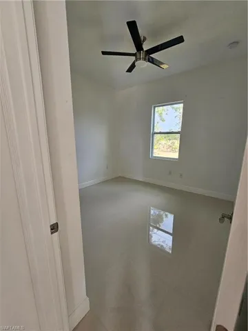 Unfurnished room with baseboards and ceiling fan