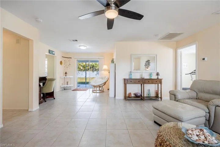 Living room featuring light tile patterned floors and ceiling fan
