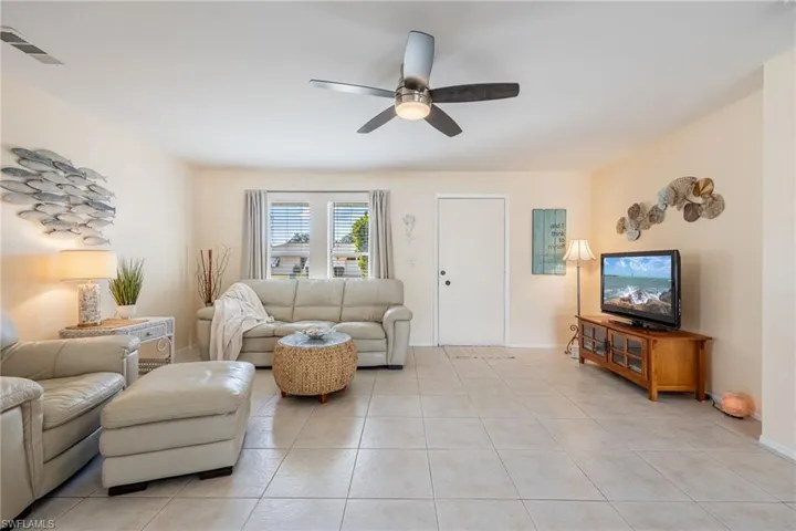 Living room featuring ceiling fan and light tile patterned flooring