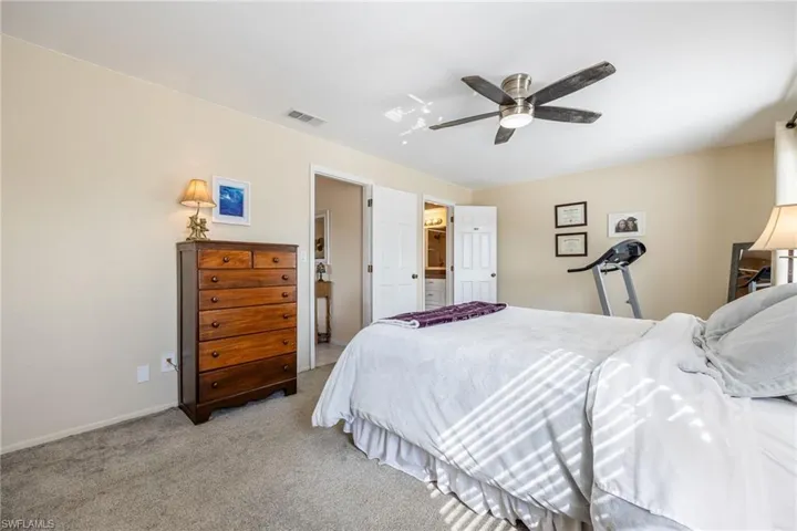 Carpeted bedroom featuring ceiling fan