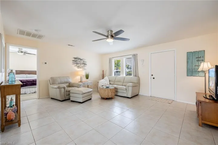 Tiled living room featuring ceiling fan