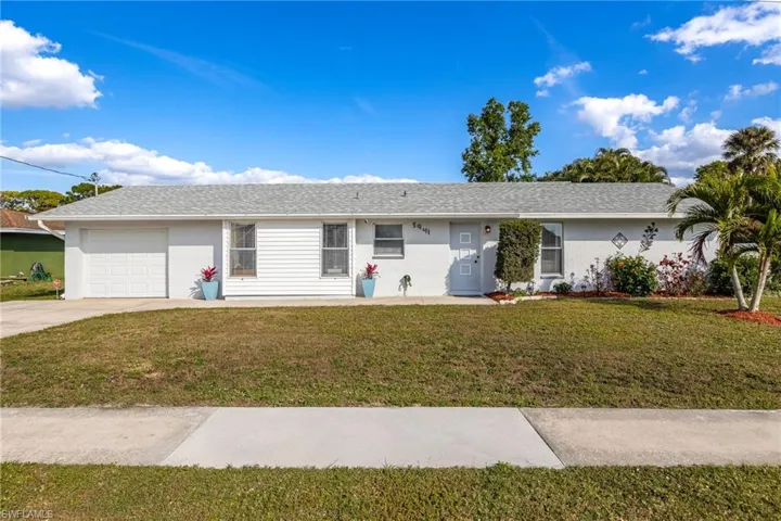 Single story home featuring a garage and a front yard