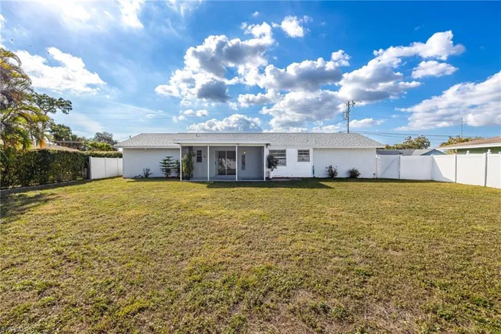 Back of property featuring a yard