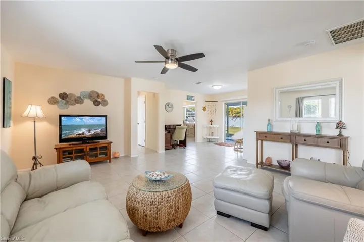 Living room featuring light tile patterned flooring and ceiling fan
