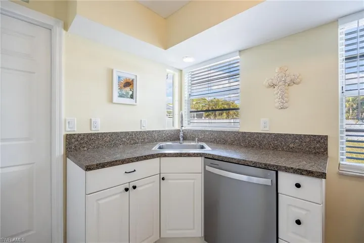 Kitchen featuring white cabinetry, sink, and stainless steel dishwasher