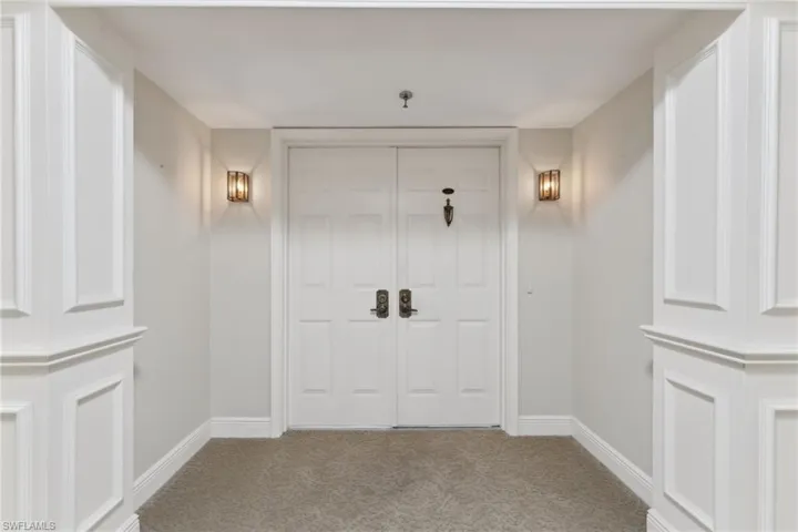 Carpeted foyer featuring baseboards