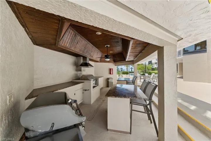 View of patio / terrace with an outdoor kitchen, outdoor wet bar, a grill, and ceiling fan