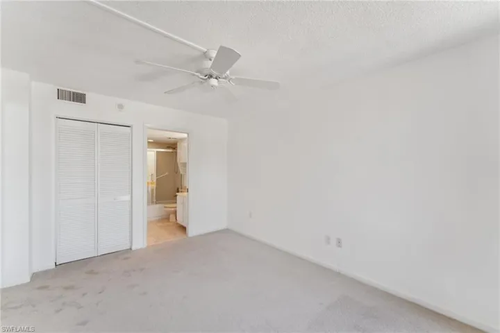 Unfurnished bedroom with light carpet, visible vents, a closet, and a textured ceiling