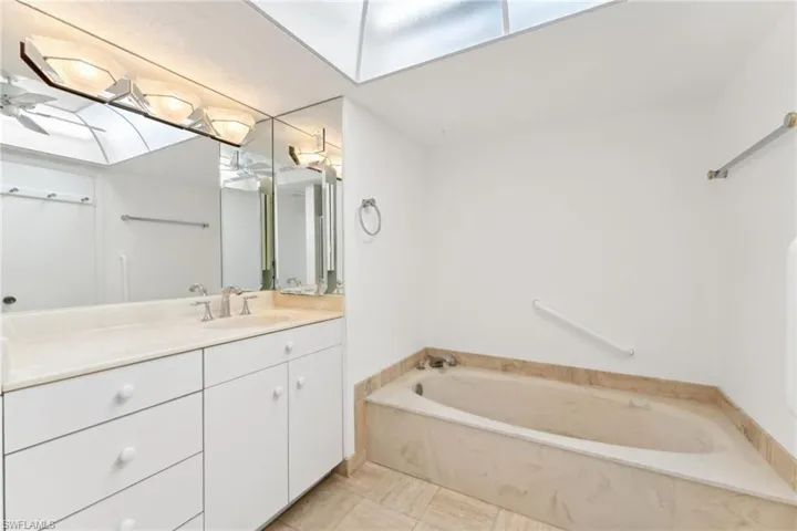 Full bathroom with vanity and a garden tub