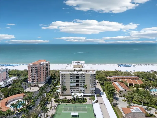 Drone / aerial view featuring a water view, a view of the beach, and a city view