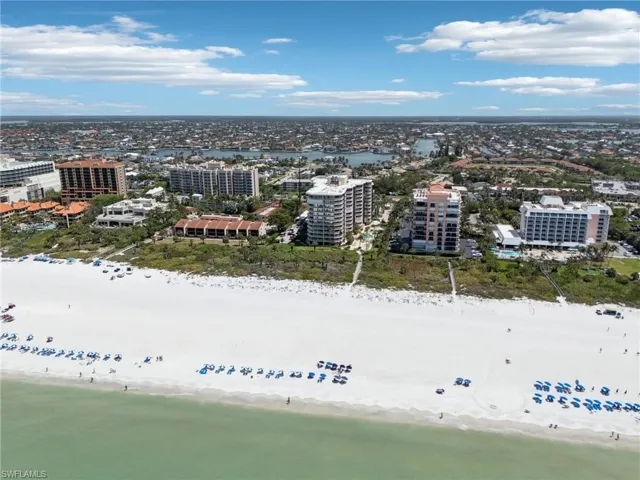 Birds eye view of property featuring a water view, a view of the beach, and a city view