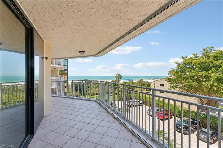 Balcony featuring a beach view and a water view
