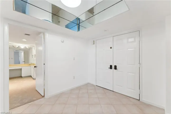 Foyer featuring baseboards and light colored carpet