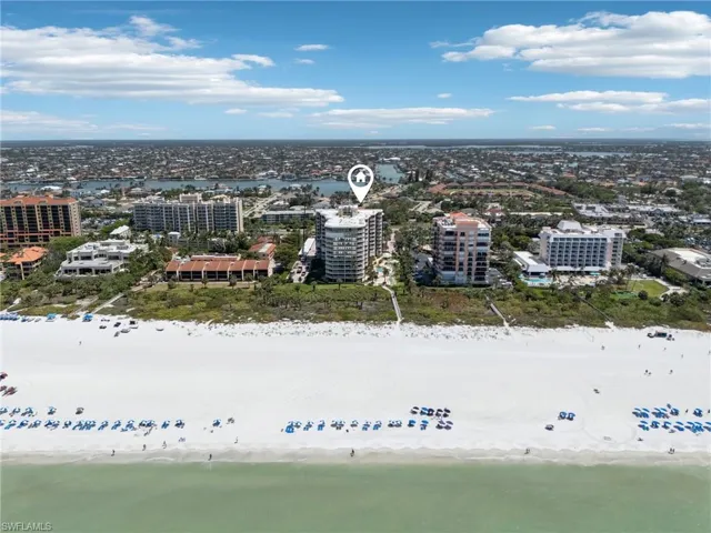 Birds eye view of property featuring a water view, a view of the beach, and a city view