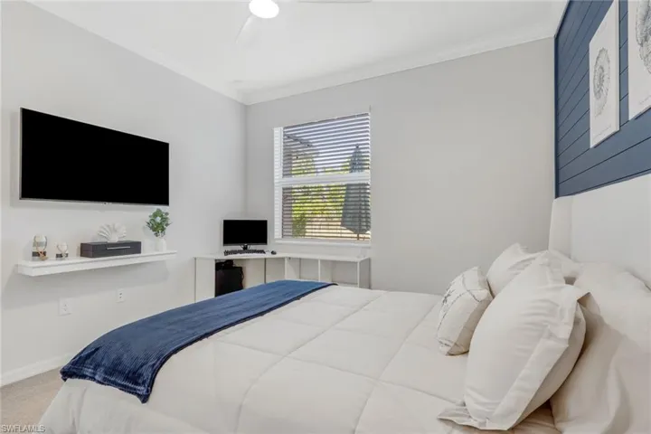 Bedroom with crown molding, a ceiling fan, and carpet flooring