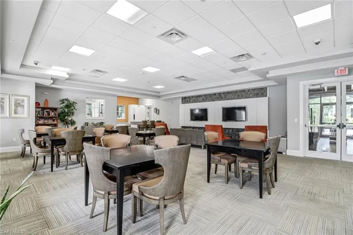 Dining space with french doors, a paneled ceiling, a raised ceiling, and light carpet