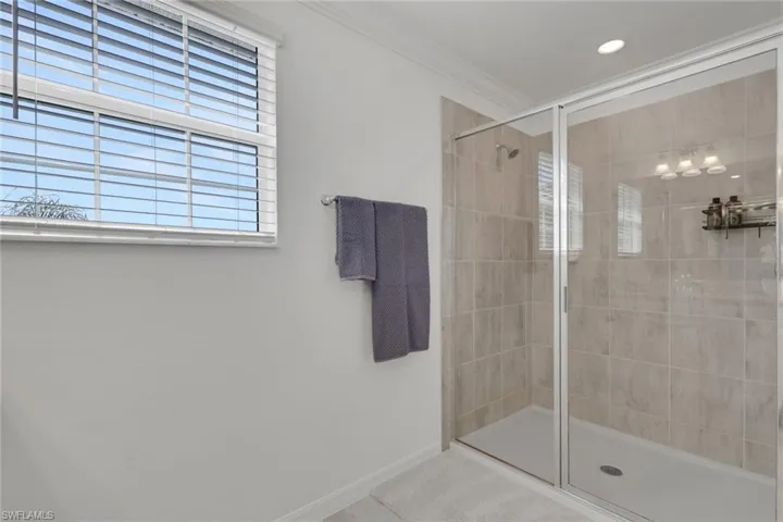 Full bathroom featuring a stall shower and ornamental molding