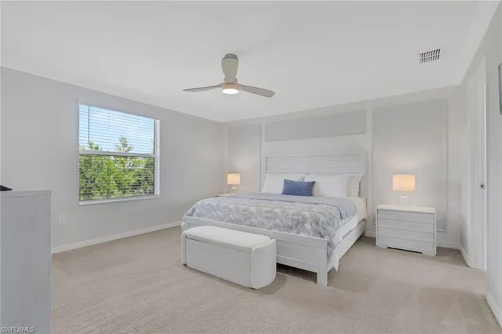 Bedroom featuring light colored carpet, a ceiling fan, and ornamental molding