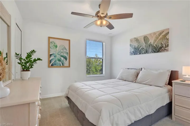 Bedroom featuring light carpet and ceiling fan
