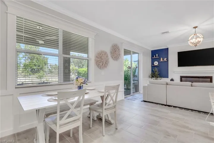 Dining space featuring a chandelier, ornamental molding, and wood tiled floors