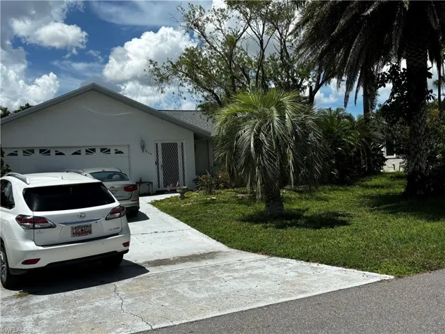 Ranch-style house with a garage and a front lawn