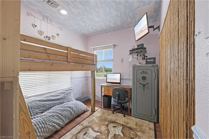 Bedroom with a desk and wood finished floors