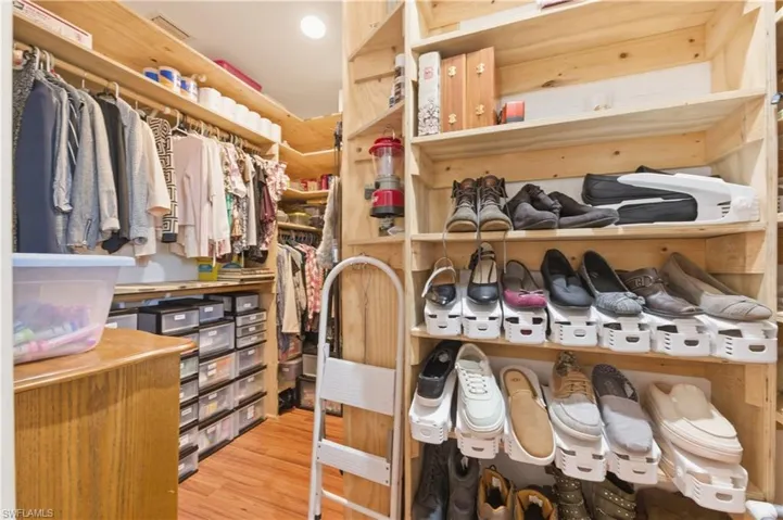 Walk in closet with light wood-style flooring