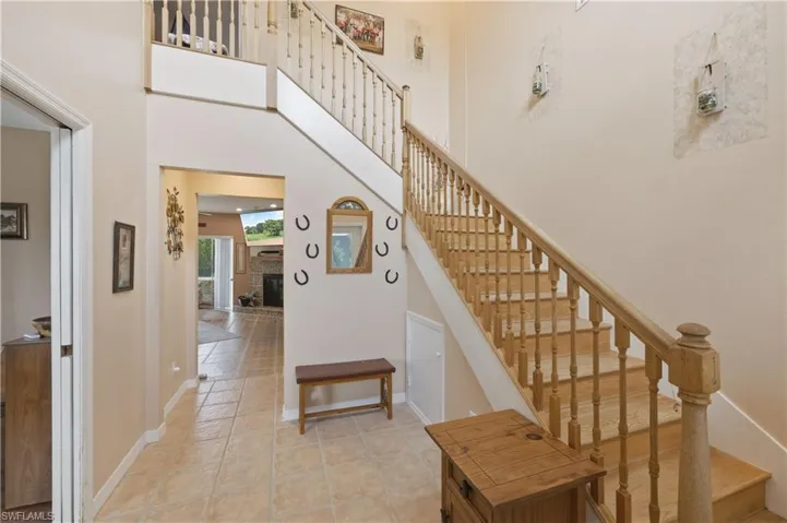 Stairway with a high ceiling, a glass covered fireplace, and tile patterned floors