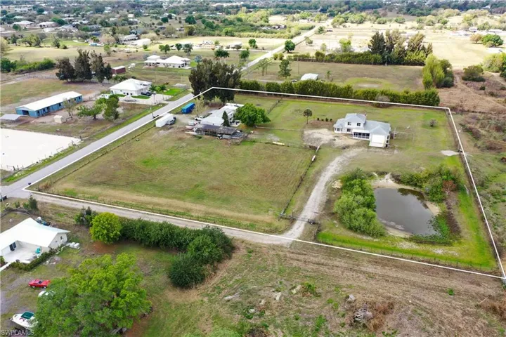 Aerial view of sparsely populated area featuring property parcel outlined and a large body of water