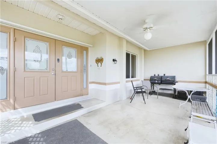 Doorway to property featuring stucco siding and a sunroom