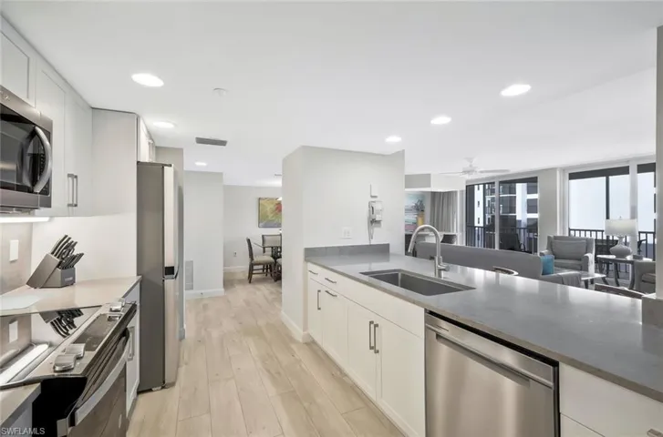 The open-concept kitchen features sleek cabinetry, stainless steel appliances, and expansive countertops.