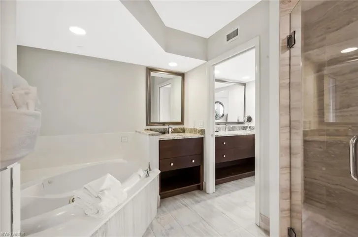 Relax in the luxurious updated bathroom featuring a jetted tub and walk in shower.