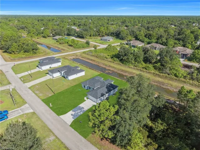 Newly constructed residence featuring a gray shingle roof, white exterior siding, and a concrete driveway