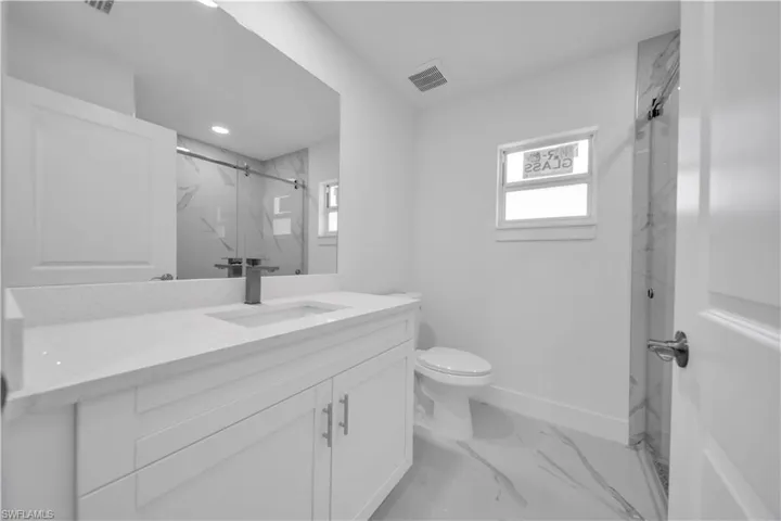 White vanity with dual doors and three drawers, white countertop, integrated sink, and dark-finish faucet