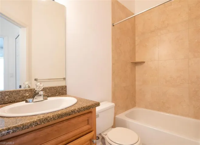 Bathroom featuring vanity, shower / tub combination, and toilet