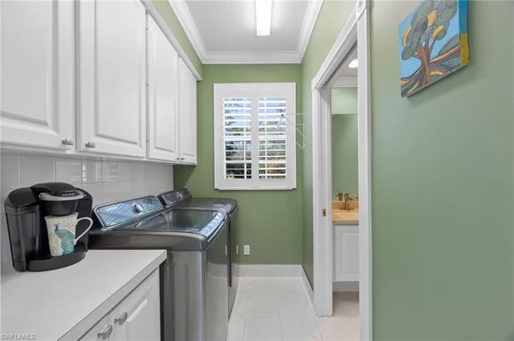 Laundry room located at the end of the kitchen and includes a half bath and coffee bar