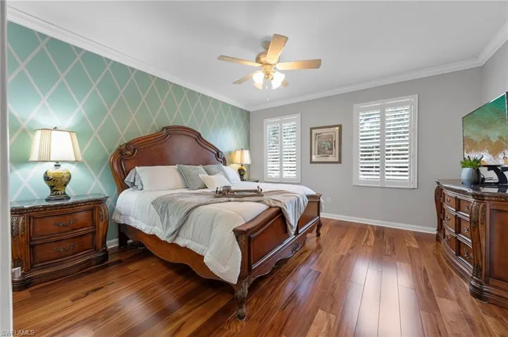 Primary bedroom with wall floors and plantation shutters