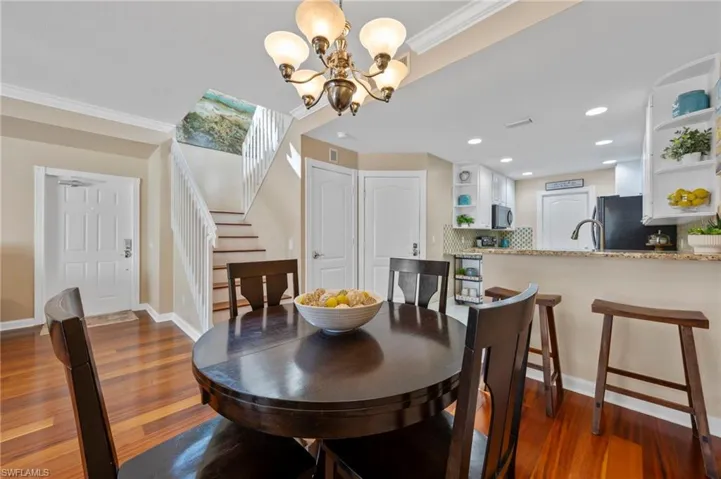 Dining area with view of front door, stairwell and kitchen bar