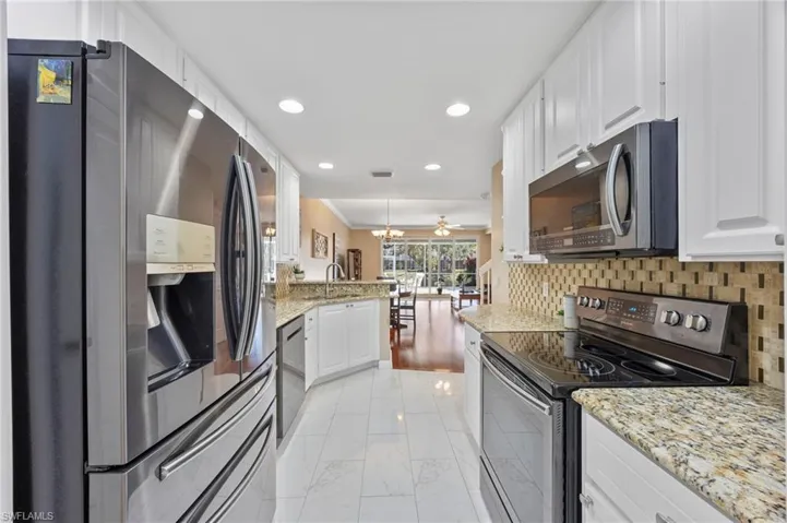 Kitchen with stainless steal appliance, granite countertops, tile backsplash & tile flooring