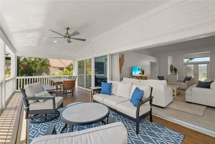 Deck featuring ceiling fan, an outdoor living / dining area, and french doors