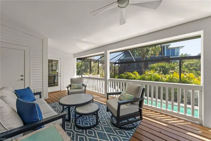 Sunroom / solarium featuring outdoor furniture, ceiling fan, vaulted ceiling, and a deck