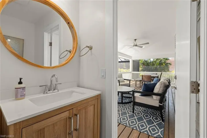 Bathroom with vanity, dark wood finished floors, vaulted ceiling, and a ceiling fan