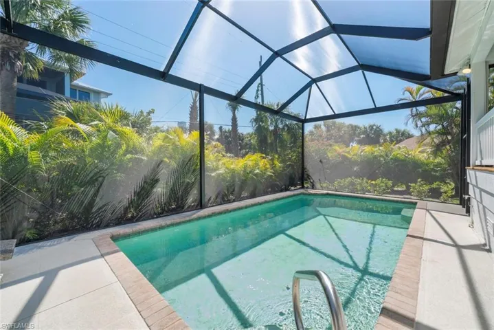 Outdoor pool featuring a sunroom, a lanai, and a patio area