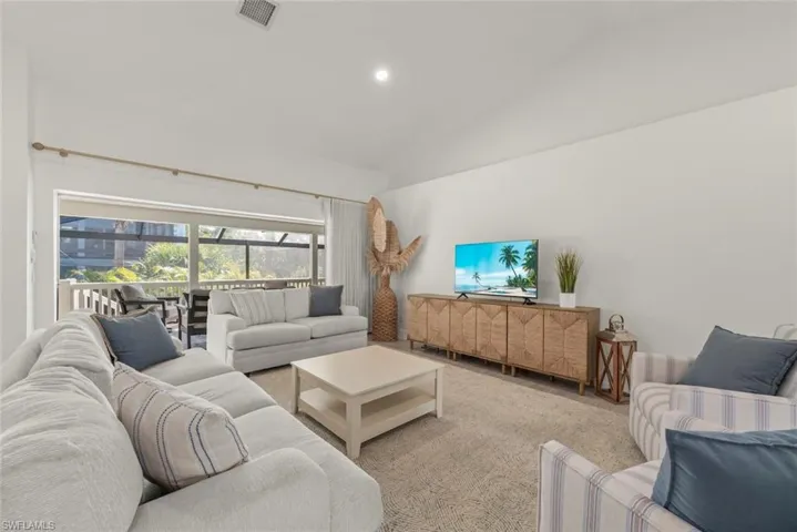 Carpeted living room featuring lofted ceiling and recessed lighting